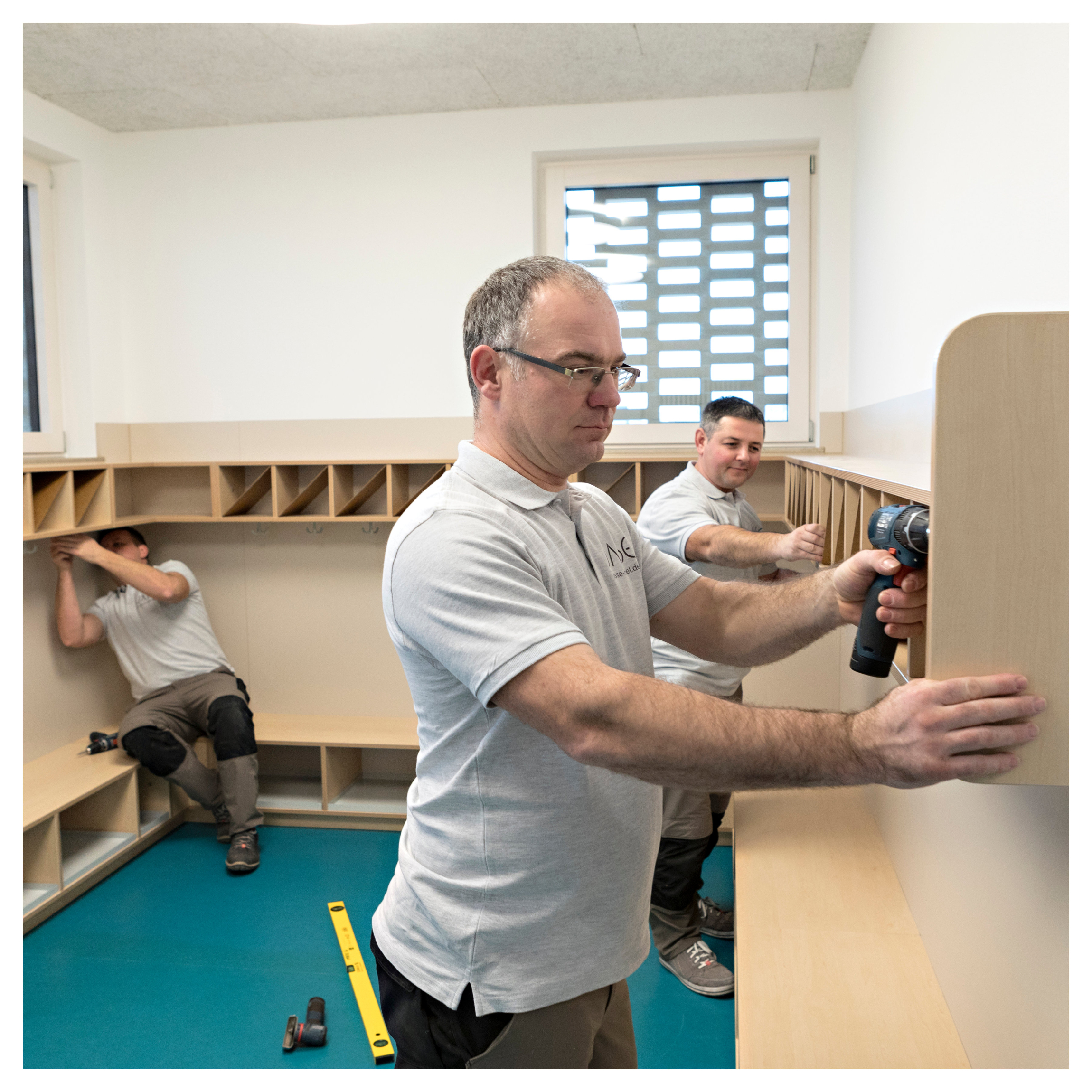 Schreiner bauen Kindergarderobe auf
